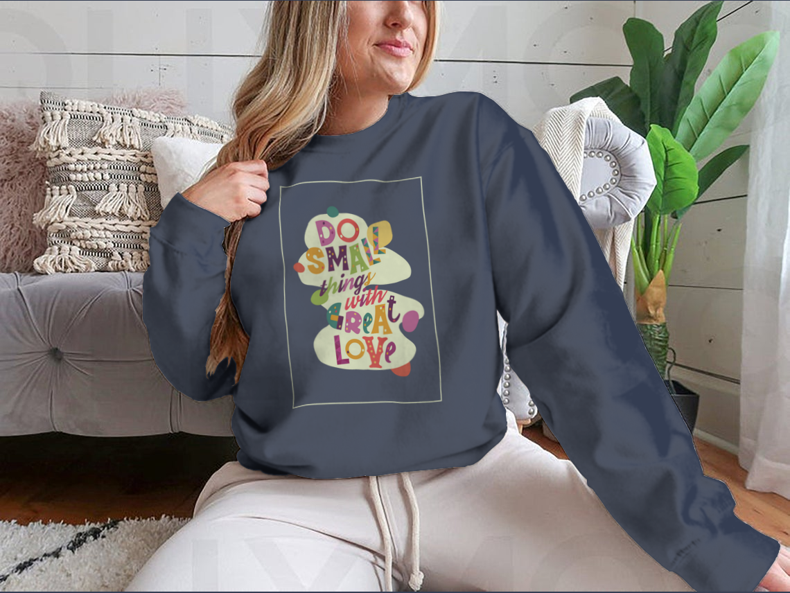 A cozy sweatshirt featuring the inspirational quote 'Do Small Things With Great Love', showcasing a classic fit and soft fabric.