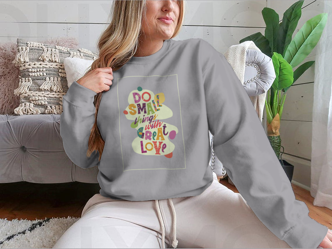 A cozy sweatshirt featuring the inspirational quote 'Do Small Things With Great Love', showcasing a classic fit and soft fabric.