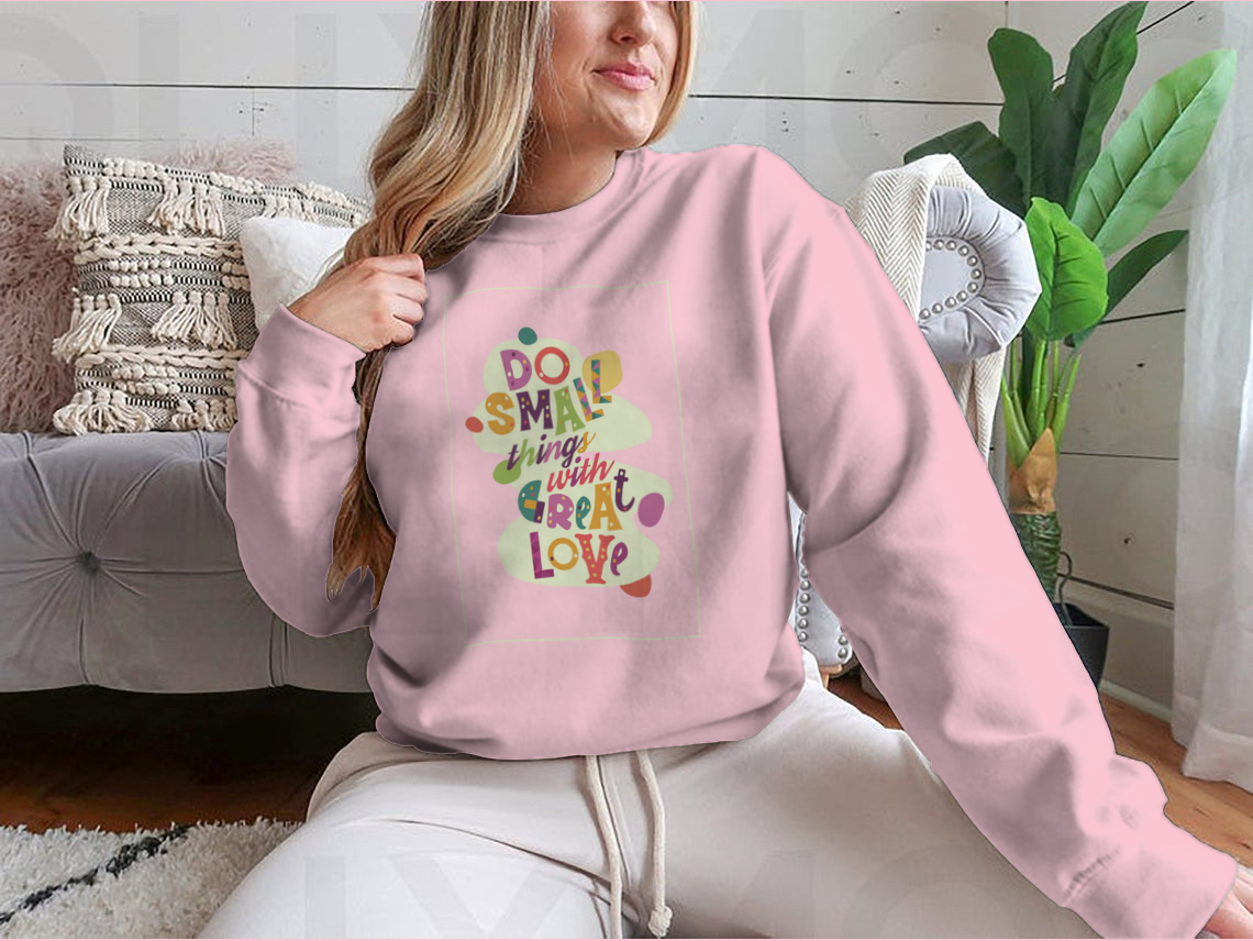 A cozy sweatshirt featuring the inspirational quote 'Do Small Things With Great Love', showcasing a classic fit and soft fabric.