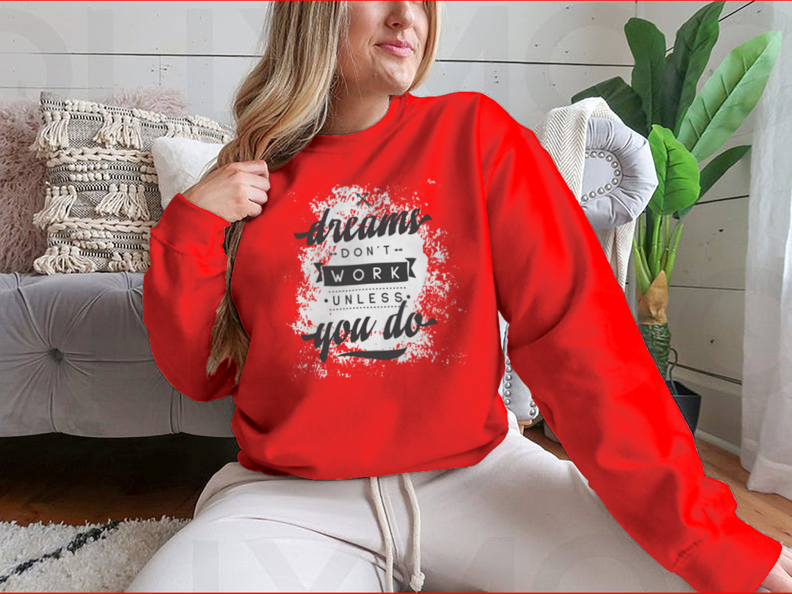 A cozy sweatshirt featuring the motivational phrase 'Dreams Don't Work Unless You Do', made from a soft cotton-polyester blend.