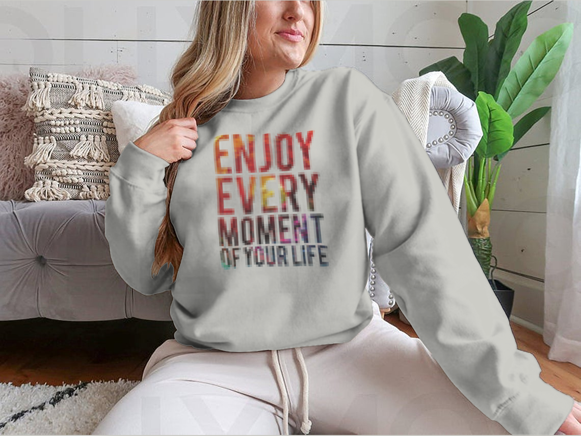 A motivational t-shirt featuring the phrase 'Enjoy Every Moment Of Your Life', made from a comfortable cotton/polyester blend.