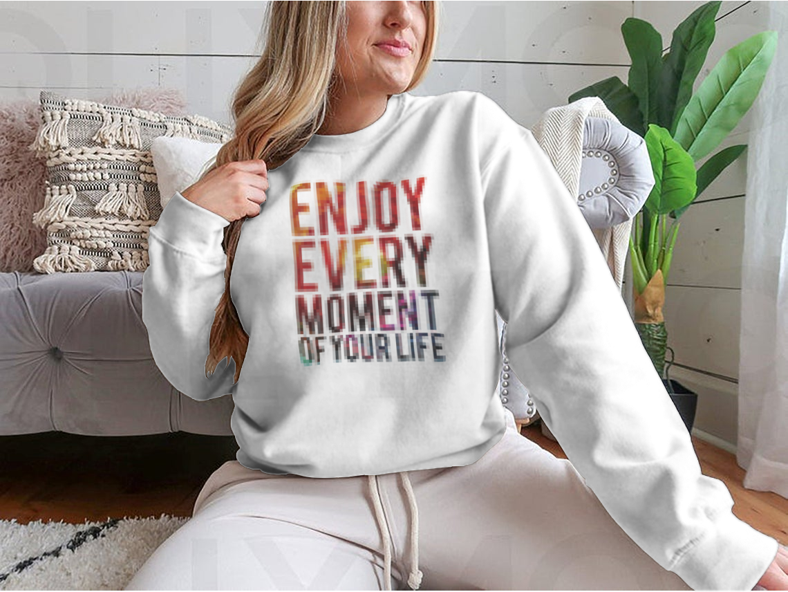 A motivational t-shirt featuring the phrase 'Enjoy Every Moment Of Your Life', made from a comfortable cotton/polyester blend.