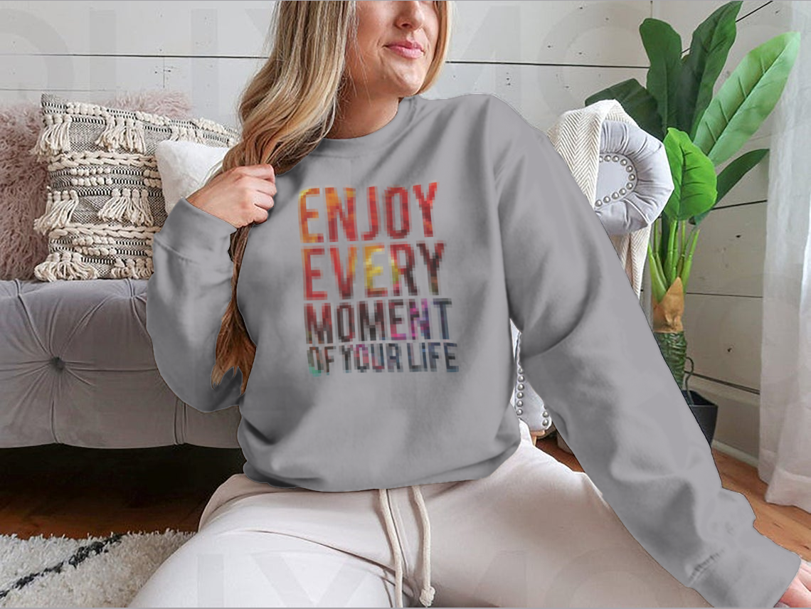 A motivational t-shirt featuring the phrase 'Enjoy Every Moment Of Your Life', made from a comfortable cotton/polyester blend.