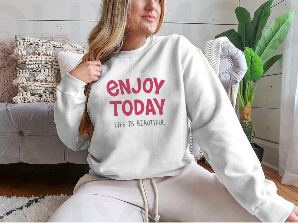 A comfortable t-shirt featuring hand-drawn typography that reads 'Enjoy Today', showcasing a stylish and inspirational design.