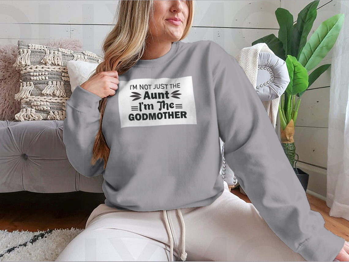 A stylish t-shirt featuring the phrase 'I'M Not Just The Aunt I'M The Godmother' in a fun design, showcasing its comfortable fit and quality fabric.