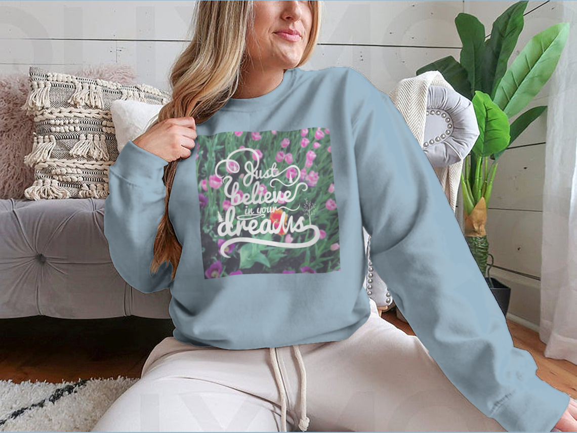 A stylish apparel featuring a blurred background with vibrant tulips and the motivational phrase 'Just Believe In Your Dreams'.