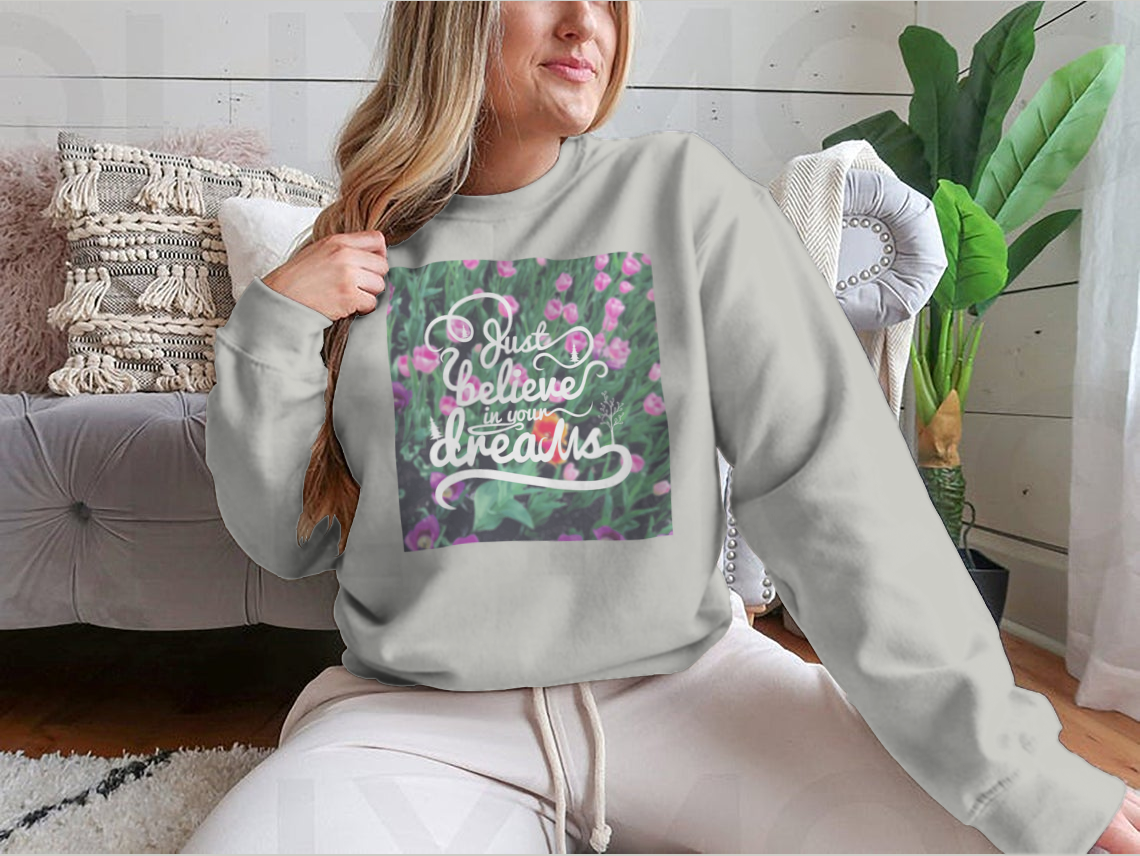 A stylish apparel featuring a blurred background with vibrant tulips and the motivational phrase 'Just Believe In Your Dreams'.