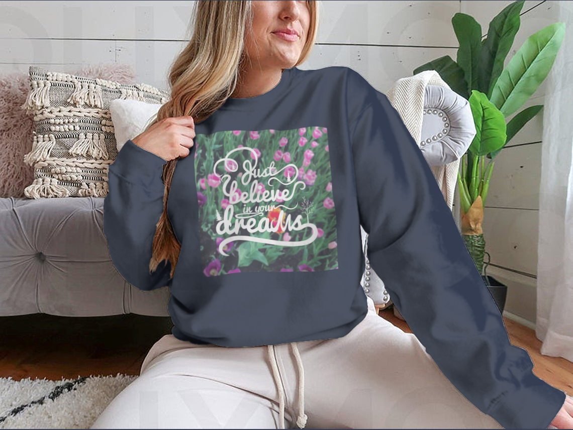 A stylish apparel featuring a blurred background with vibrant tulips and the motivational phrase 'Just Believe In Your Dreams'.