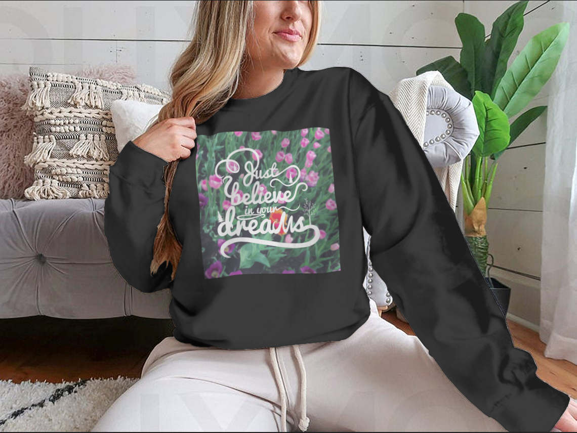 A stylish apparel featuring a blurred background with vibrant tulips and the motivational phrase 'Just Believe In Your Dreams'.