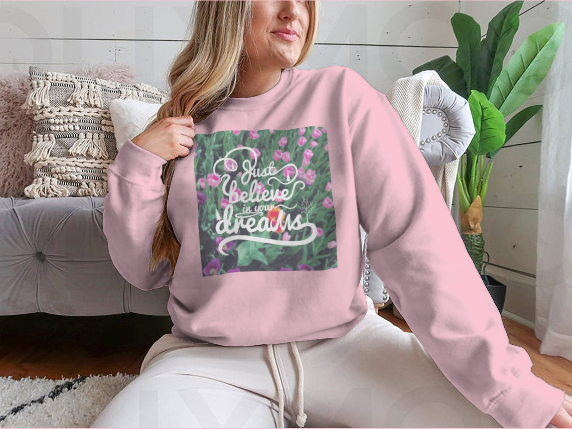 A stylish apparel featuring a blurred background with vibrant tulips and the motivational phrase 'Just Believe In Your Dreams'.