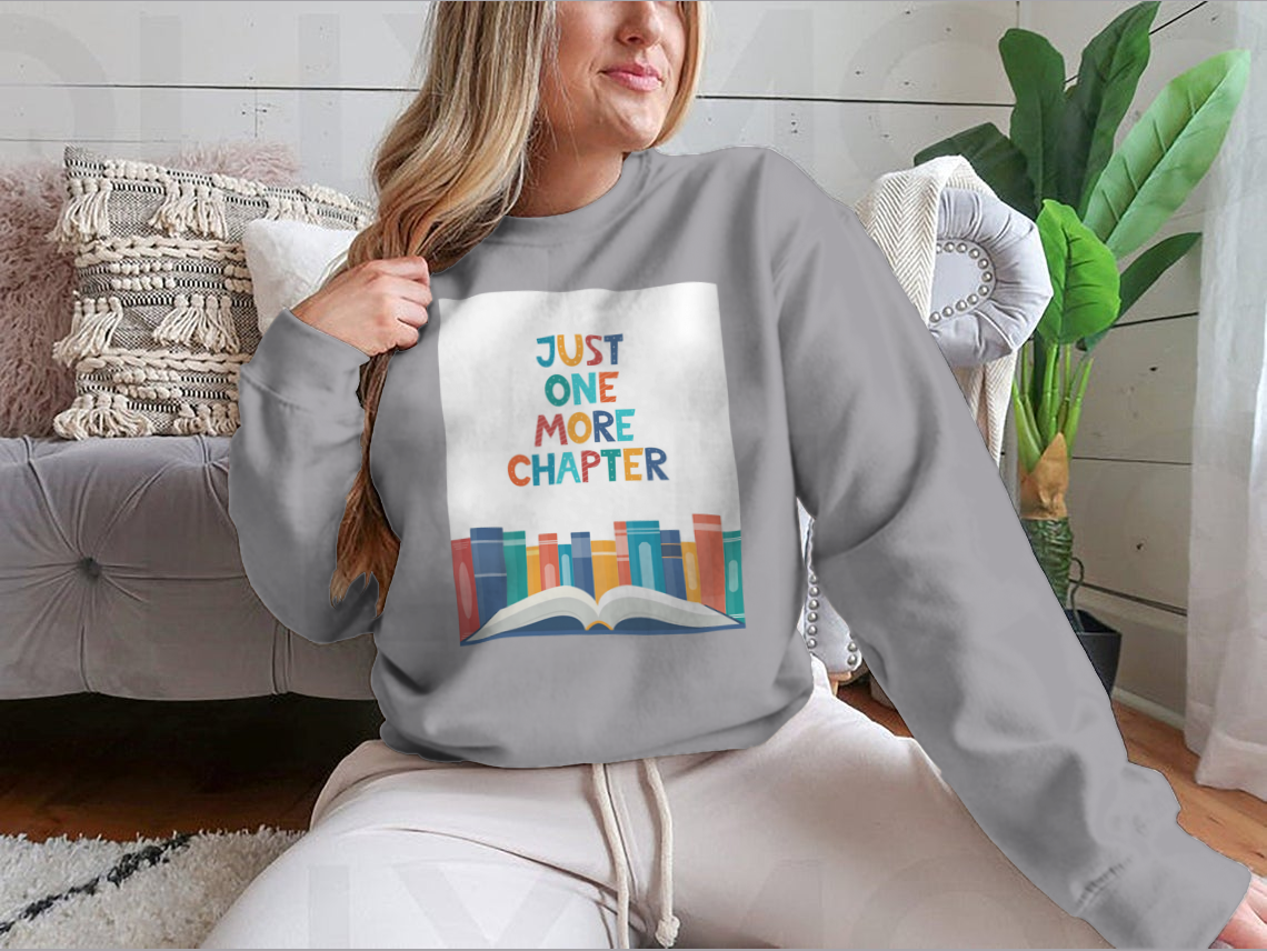 A cozy sweatshirt featuring the phrase 'Just One More Chapter', perfect for book lovers, made from soft cotton fabric.