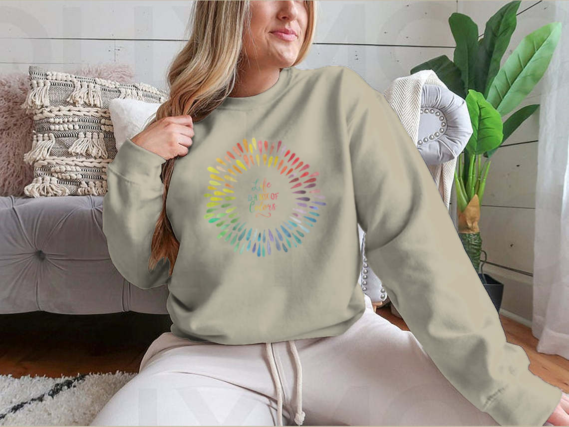 A cozy sweatshirt featuring the motivational quote 'Life Is A Box Of Colors' in vibrant colors, perfect for casual wear.