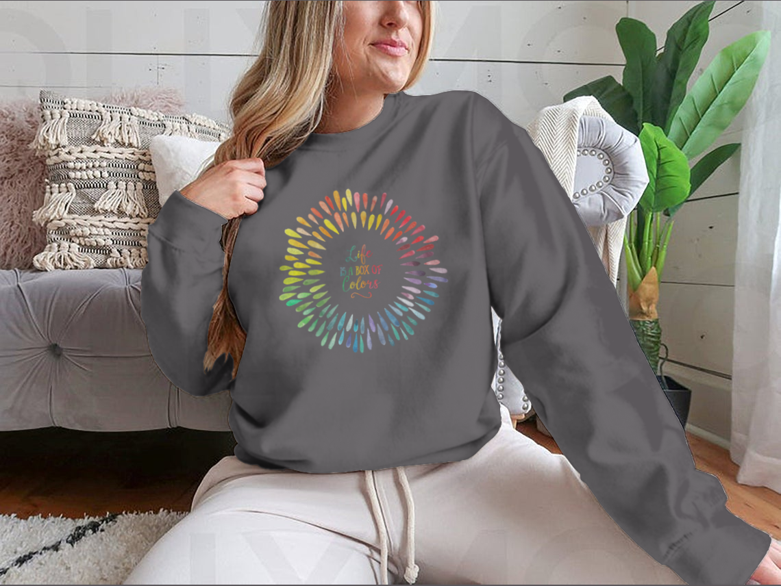 A cozy sweatshirt featuring the motivational quote 'Life Is A Box Of Colors' in vibrant colors, perfect for casual wear.