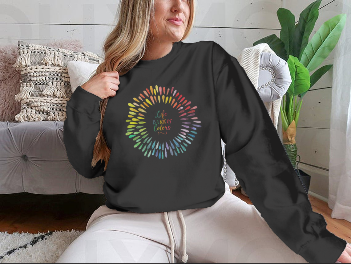 A cozy sweatshirt featuring the motivational quote 'Life Is A Box Of Colors' in vibrant colors, perfect for casual wear.