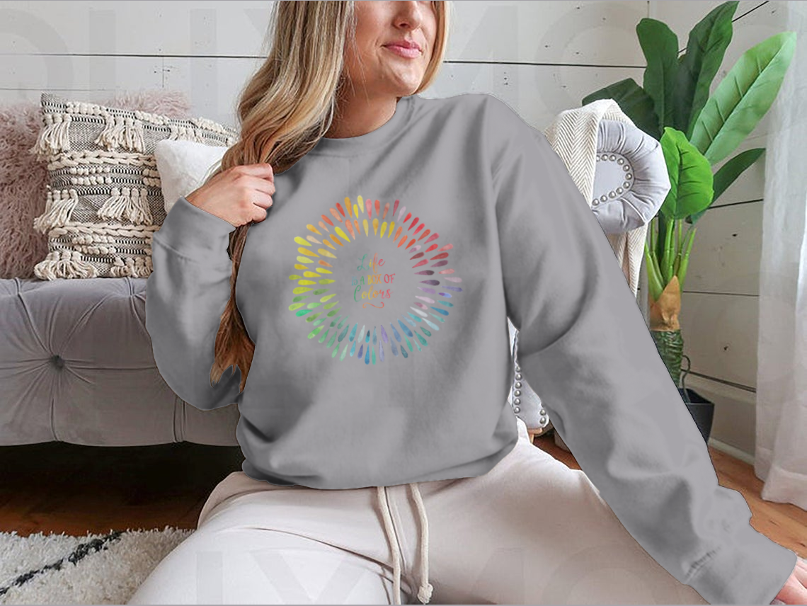 A cozy sweatshirt featuring the motivational quote 'Life Is A Box Of Colors' in vibrant colors, perfect for casual wear.