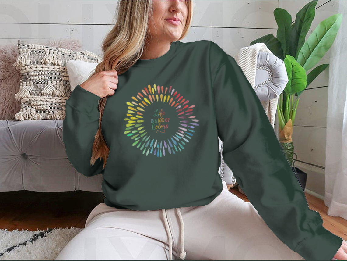 A cozy sweatshirt featuring the motivational quote 'Life Is A Box Of Colors' in vibrant colors, perfect for casual wear.