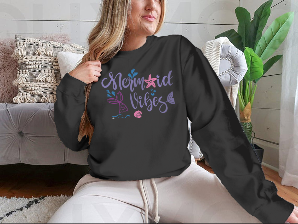 A cozy sweatshirt featuring a whimsical mermaid design, made from 100% cotton, perfect for casual wear.