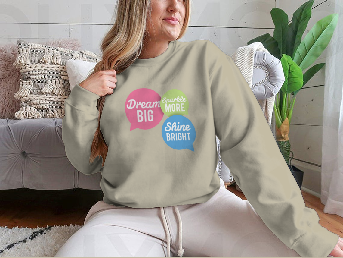 A stylish t-shirt featuring a motivational Dream Big quote in colorful speech bubbles, made from a soft cotton/polyester blend.