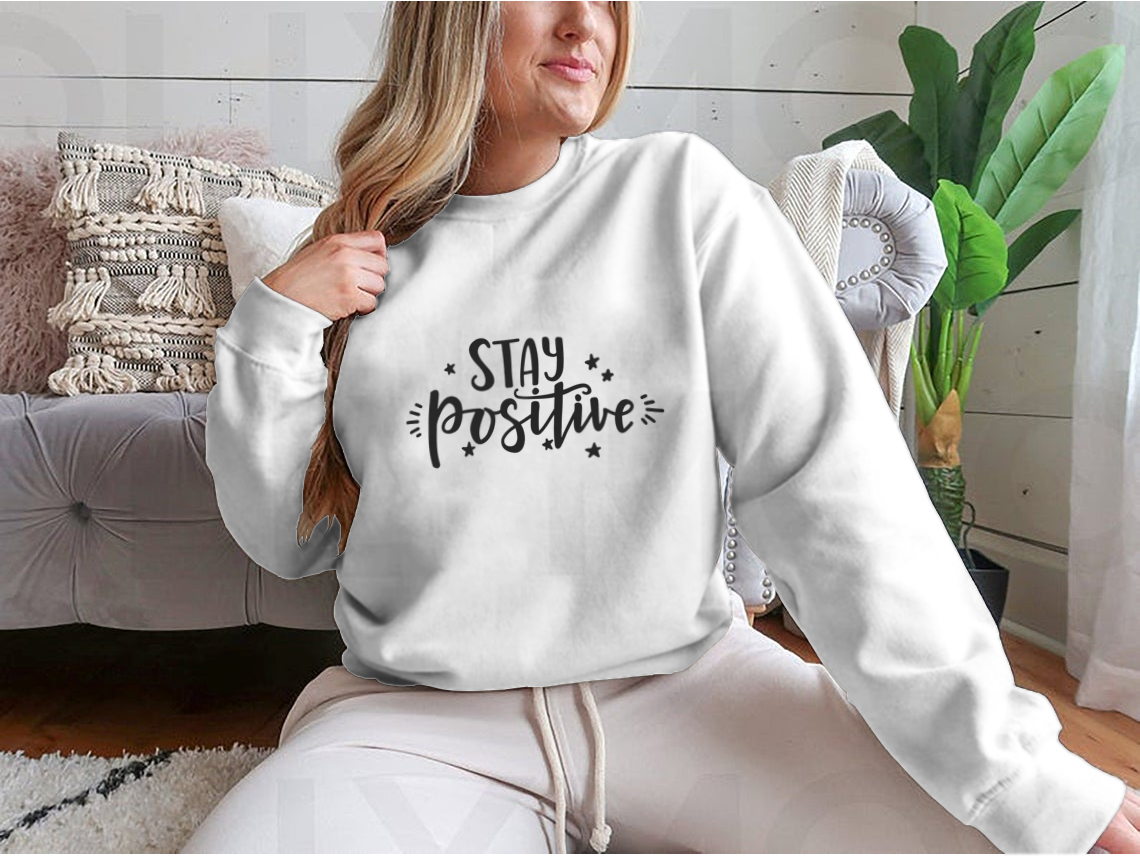 A cozy sweatshirt featuring an inspirational 'Stay Positive' design, made from a cotton/polyester blend, perfect for casual wear.