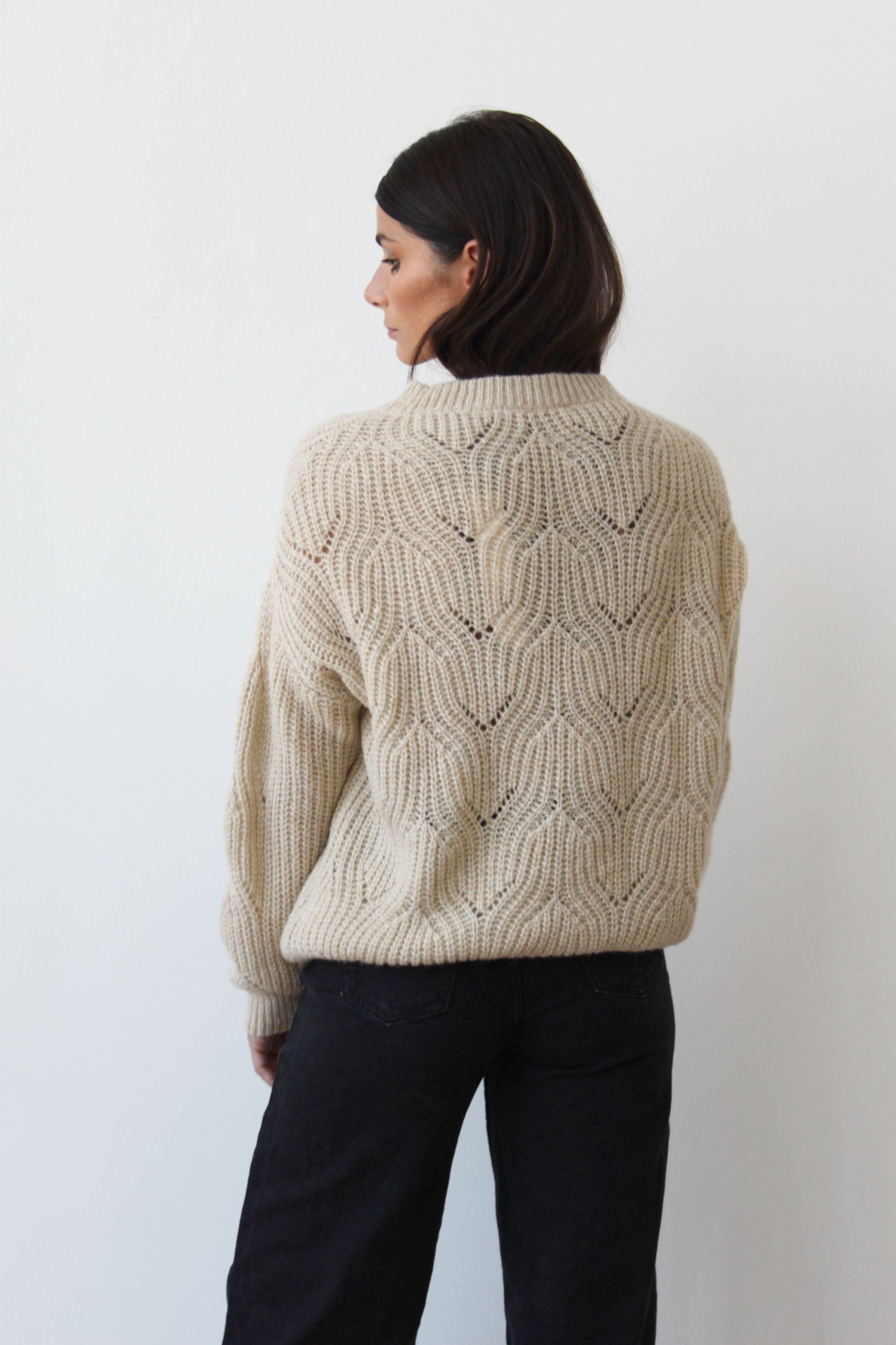 The Dune sweater displayed on a mannequin, showcasing its stylish design and versatile color.