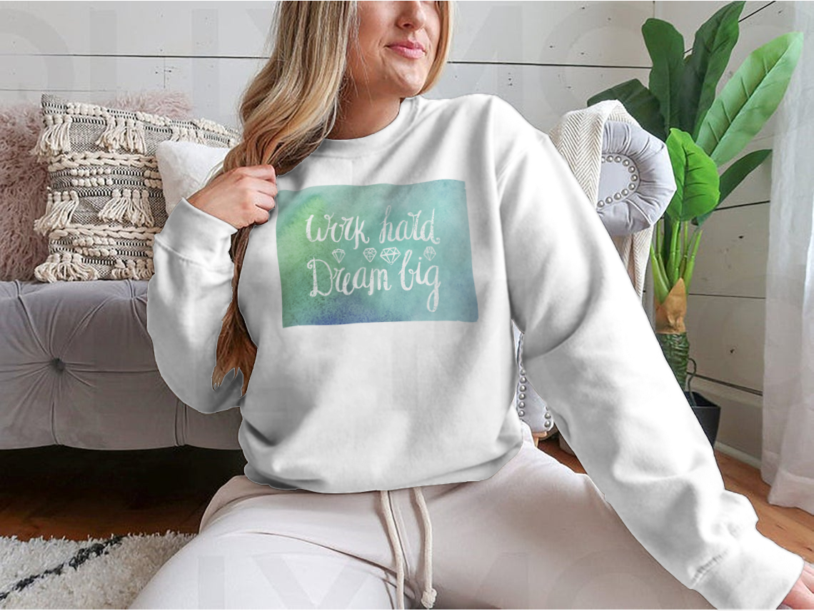 A cozy sweatshirt featuring the inspirational quote 'Work Hard Dream Big', made from a soft cotton/polyester blend, perfect for casual wear.