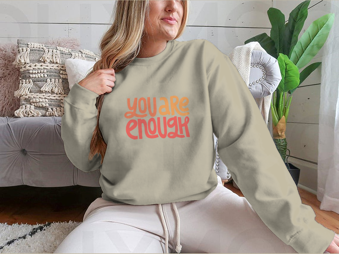 A cozy sweatshirt featuring the inspirational phrase 'You Are Enough' in stylish typography, perfect for casual wear.