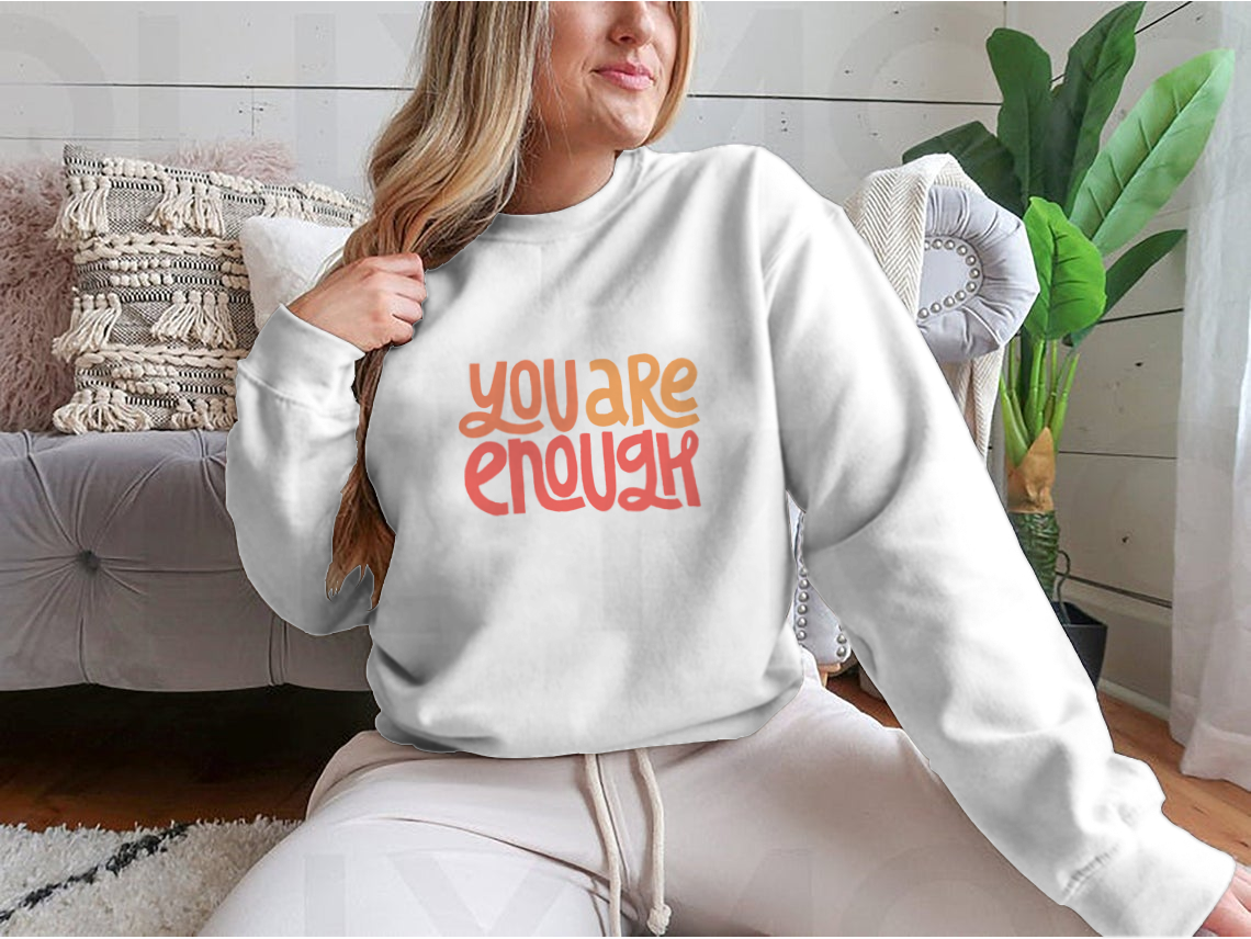 A cozy sweatshirt featuring the inspirational phrase 'You Are Enough' in stylish typography, perfect for casual wear.