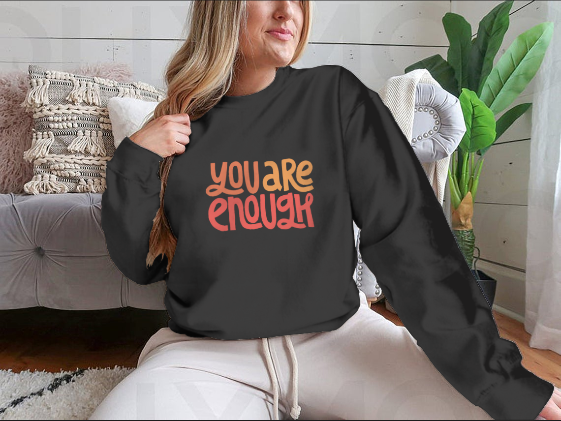 A cozy sweatshirt featuring the inspirational phrase 'You Are Enough' in stylish typography, perfect for casual wear.