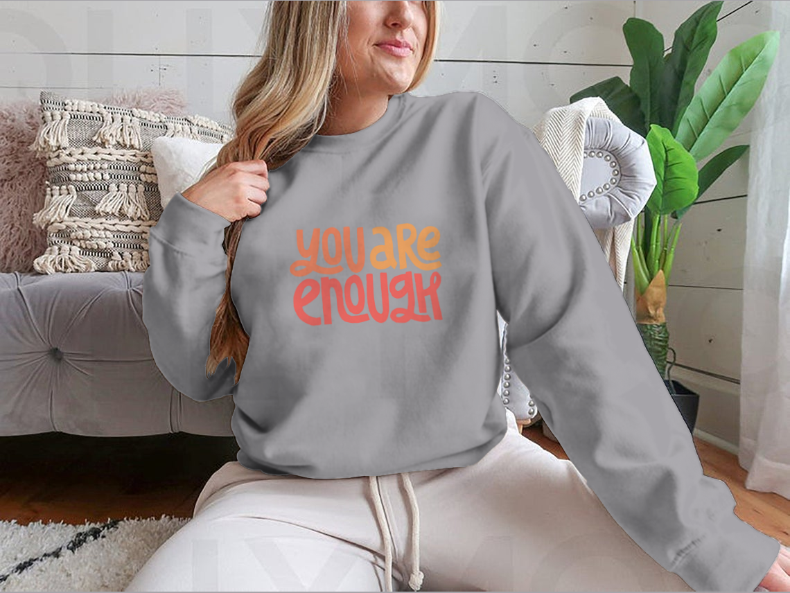 A cozy sweatshirt featuring the inspirational phrase 'You Are Enough' in stylish typography, perfect for casual wear.