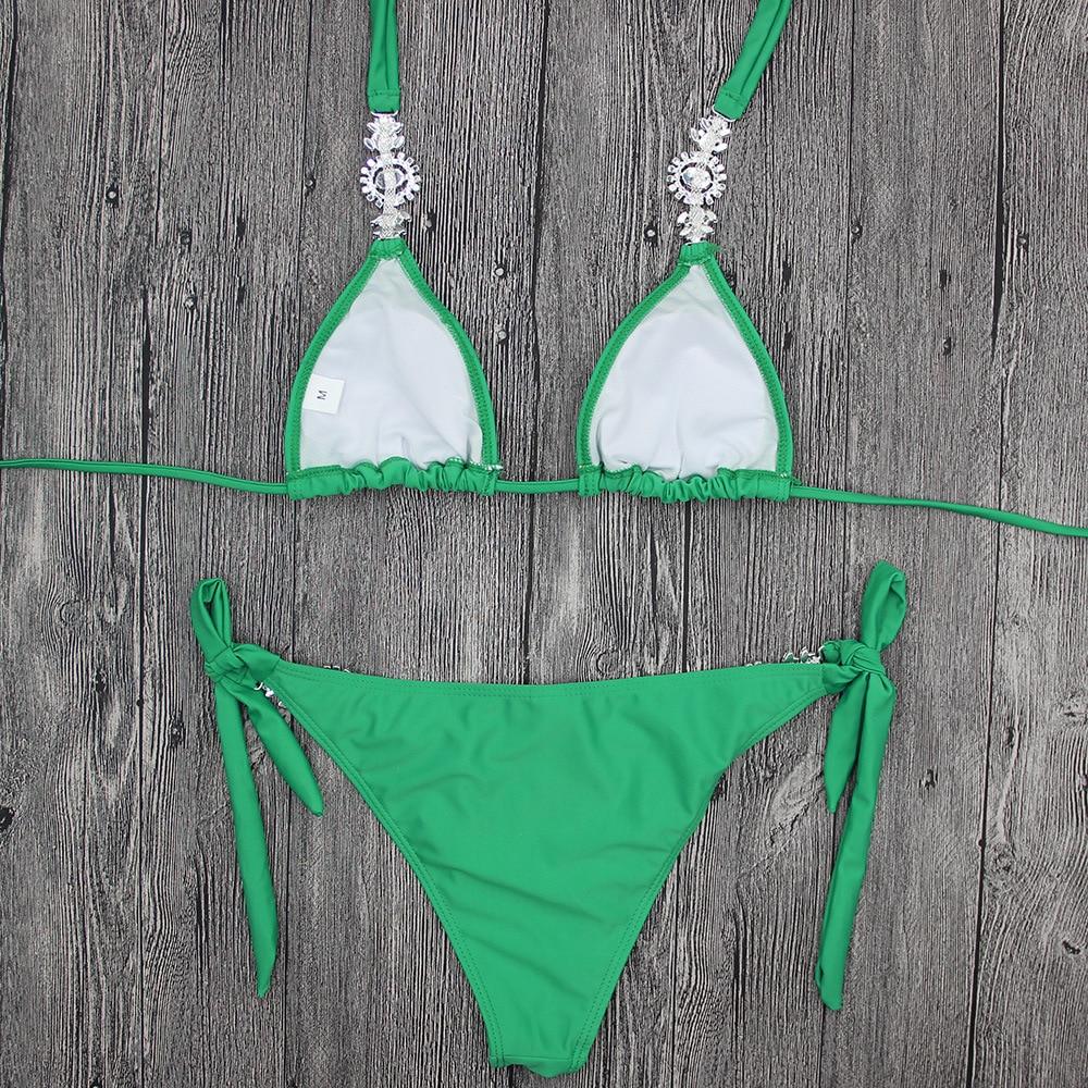 Green bikini on wooden background.