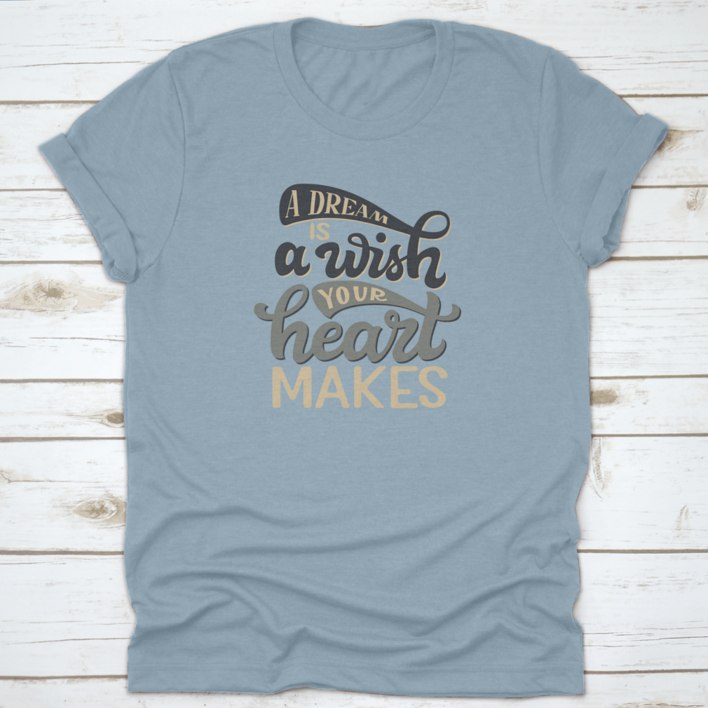 A stylish t-shirt featuring the hand-drawn quote 'A Dream Is A Wish Your Heart Makes' in elegant typography, made from soft cotton fabric.