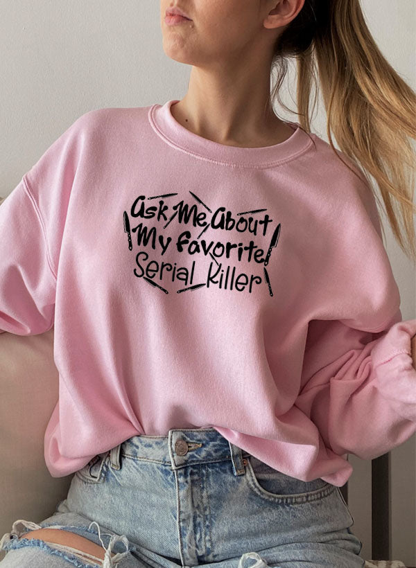 A cozy black sweatshirt featuring the phrase 'Ask Me About My Favorite Serial Killer' in bold white letters, perfect for casual wear.