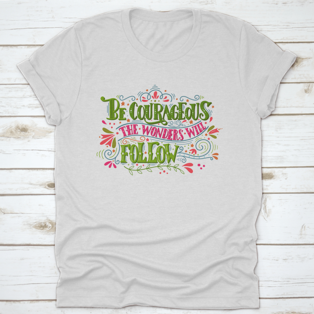 A comfortable and stylish t-shirt featuring the inspirational phrase 'Be Courageous, The Wonders Will Follow', made from 100% cotton.