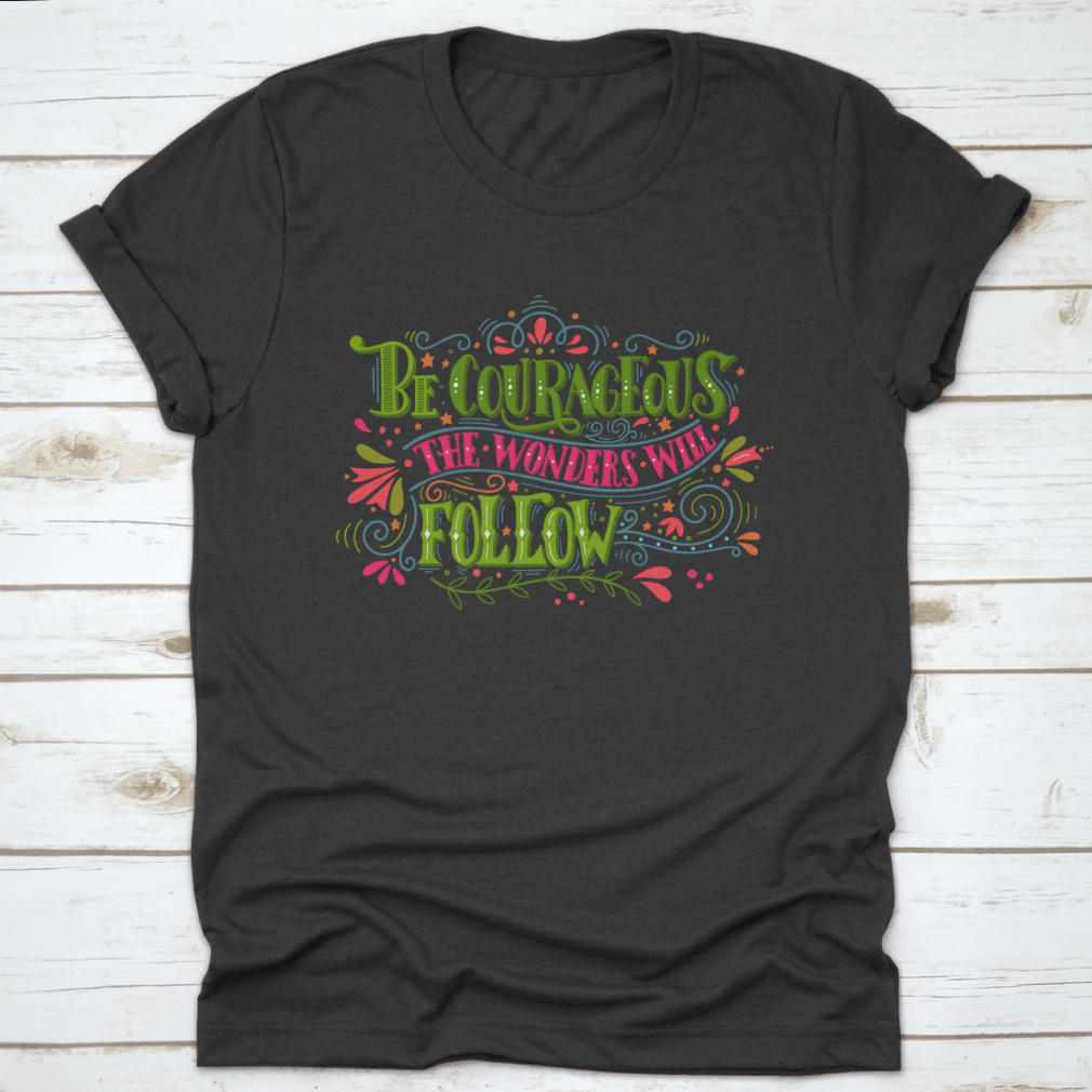 A comfortable and stylish t-shirt featuring the inspirational phrase 'Be Courageous, The Wonders Will Follow', made from 100% cotton.