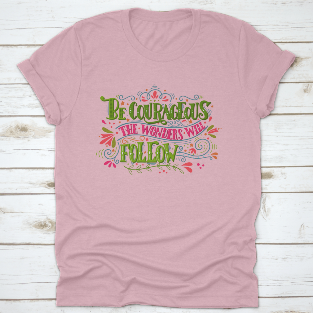 A comfortable and stylish t-shirt featuring the inspirational phrase 'Be Courageous, The Wonders Will Follow', made from 100% cotton.