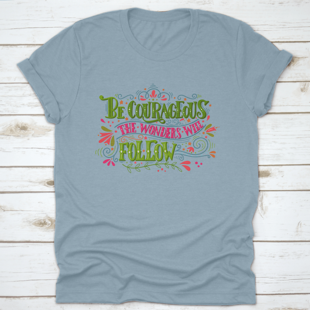 A comfortable and stylish t-shirt featuring the inspirational phrase 'Be Courageous, The Wonders Will Follow', made from 100% cotton.