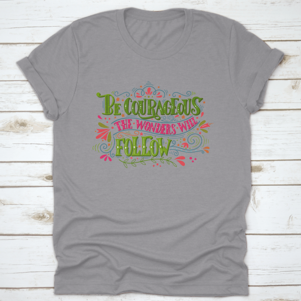 A comfortable and stylish t-shirt featuring the inspirational phrase 'Be Courageous, The Wonders Will Follow', made from 100% cotton.