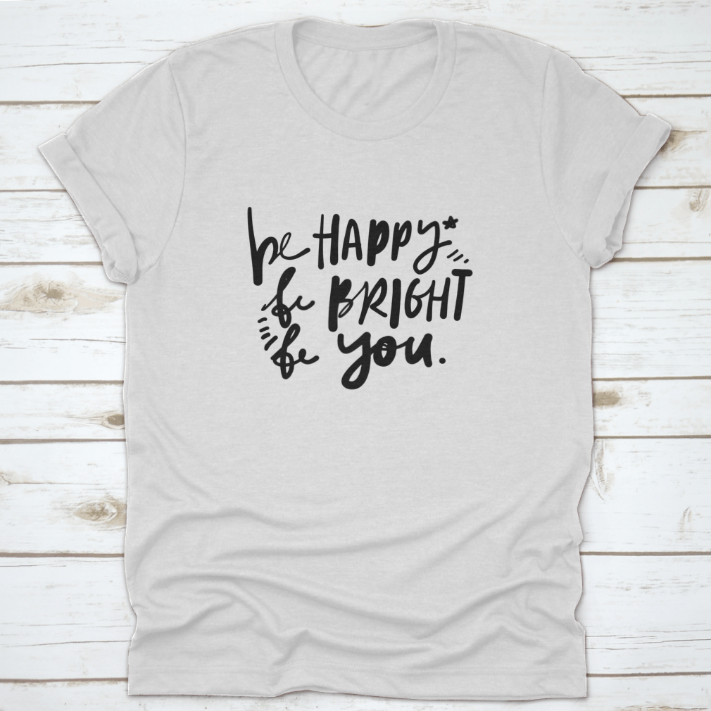 A stylish cotton apparel featuring the quote 'Be Happy, Be Bright, Be You' in hand lettering, perfect for skincare enthusiasts.