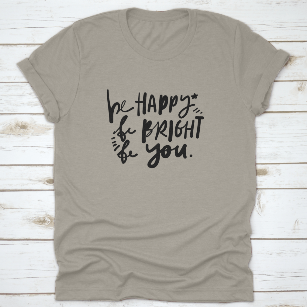 A stylish cotton apparel featuring the quote 'Be Happy, Be Bright, Be You' in hand lettering, perfect for skincare enthusiasts.