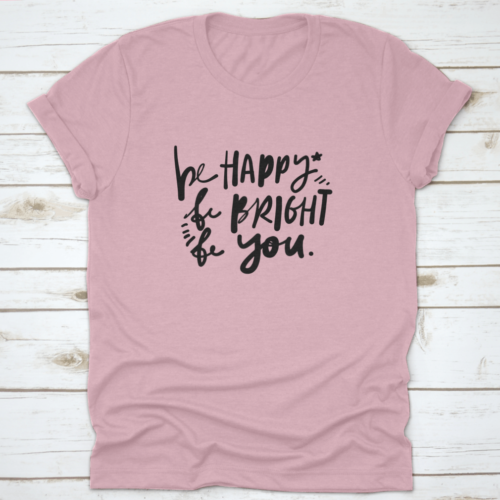 A stylish cotton apparel featuring the quote 'Be Happy, Be Bright, Be You' in hand lettering, perfect for skincare enthusiasts.