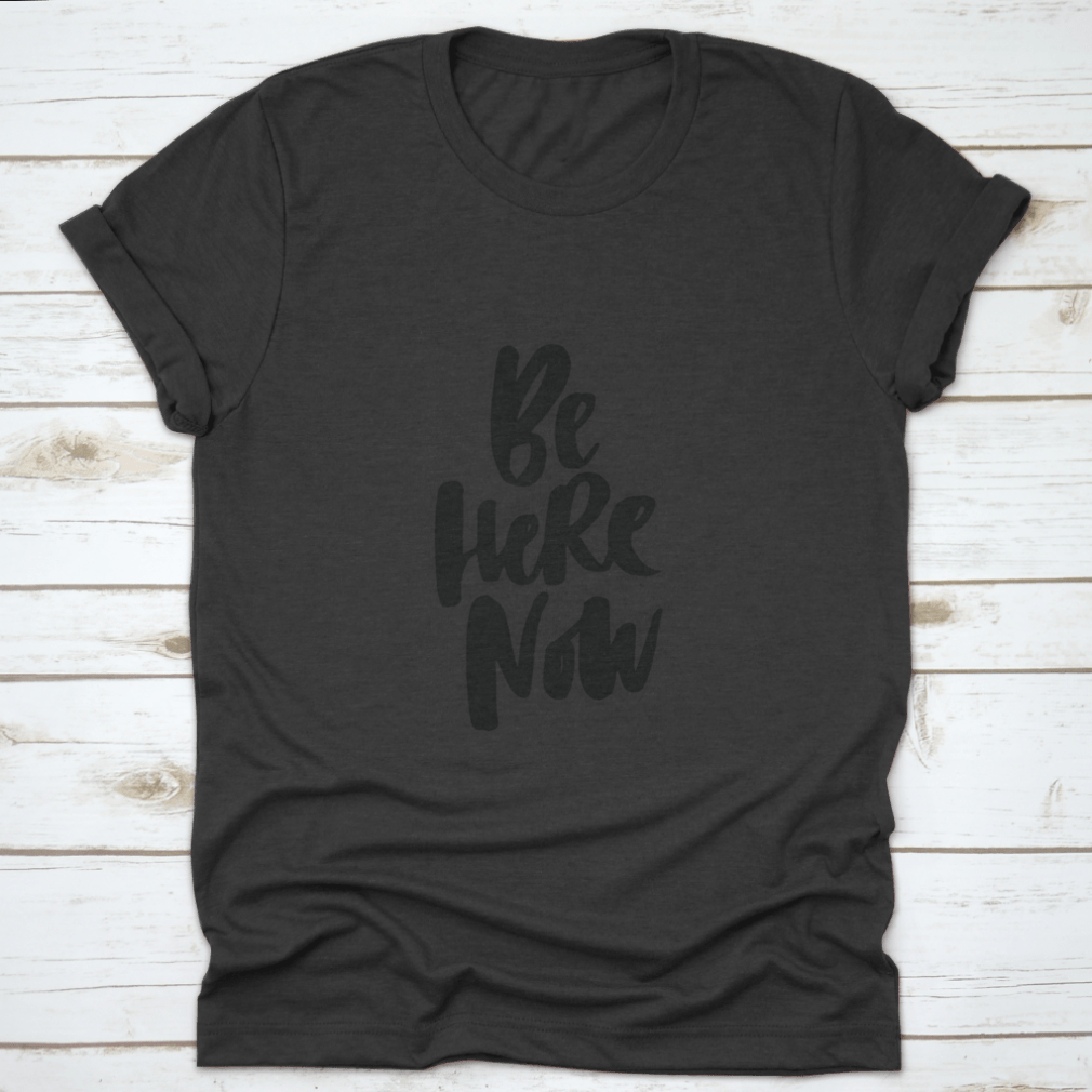 Be Here Now T-Shirt featuring hand-drawn brush pen lettering design on a soft cotton fabric.