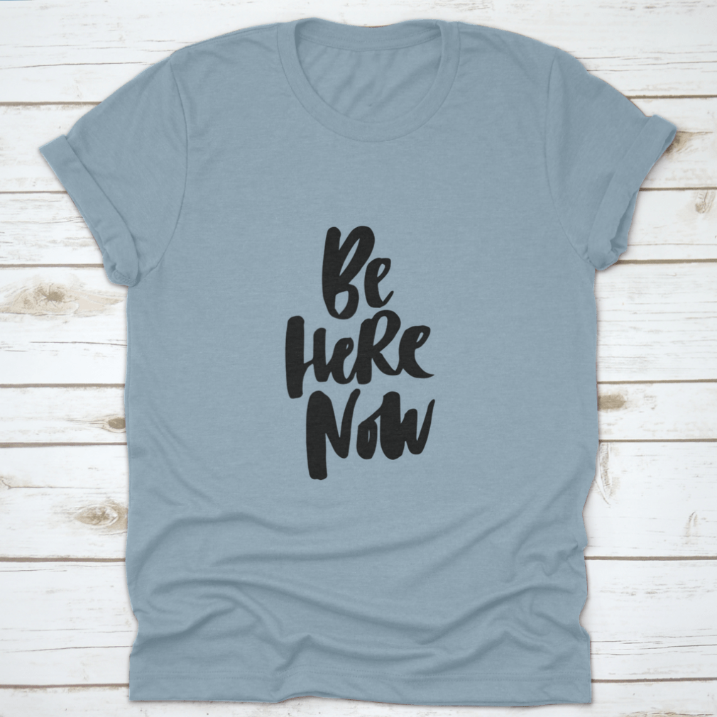 Be Here Now T-Shirt featuring hand-drawn brush pen lettering design on a soft cotton fabric.