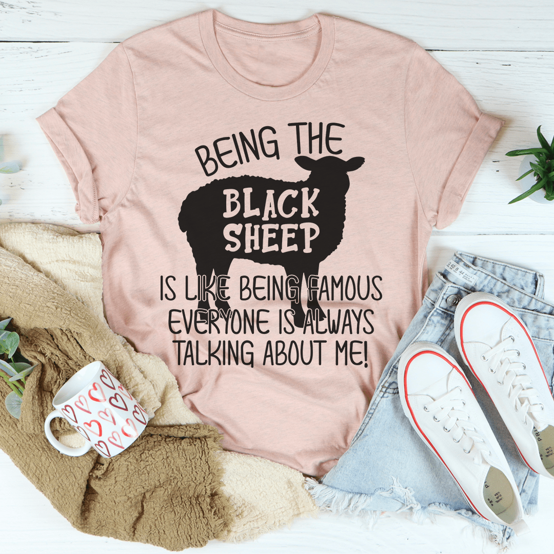 A stylish black t-shirt featuring the phrase 'Being The Black Sheep Is Like Being Famous' printed in bold letters, showcasing its soft fabric and durable stitching.