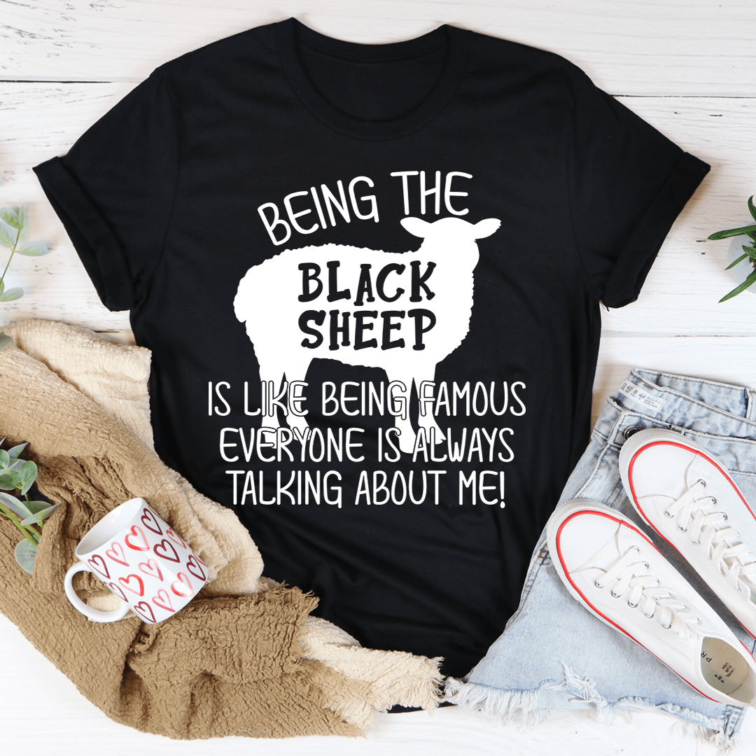 A stylish black t-shirt featuring the phrase 'Being The Black Sheep Is Like Being Famous' printed in bold letters, showcasing its soft fabric and durable stitching.