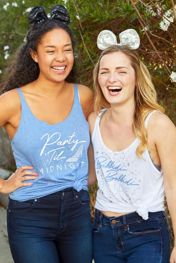 Bibbidi Bobbidi Bride tank top in white with sparkly lettering, and blue tank top with Party 'Til Midnight text, showcasing their flowy fit.