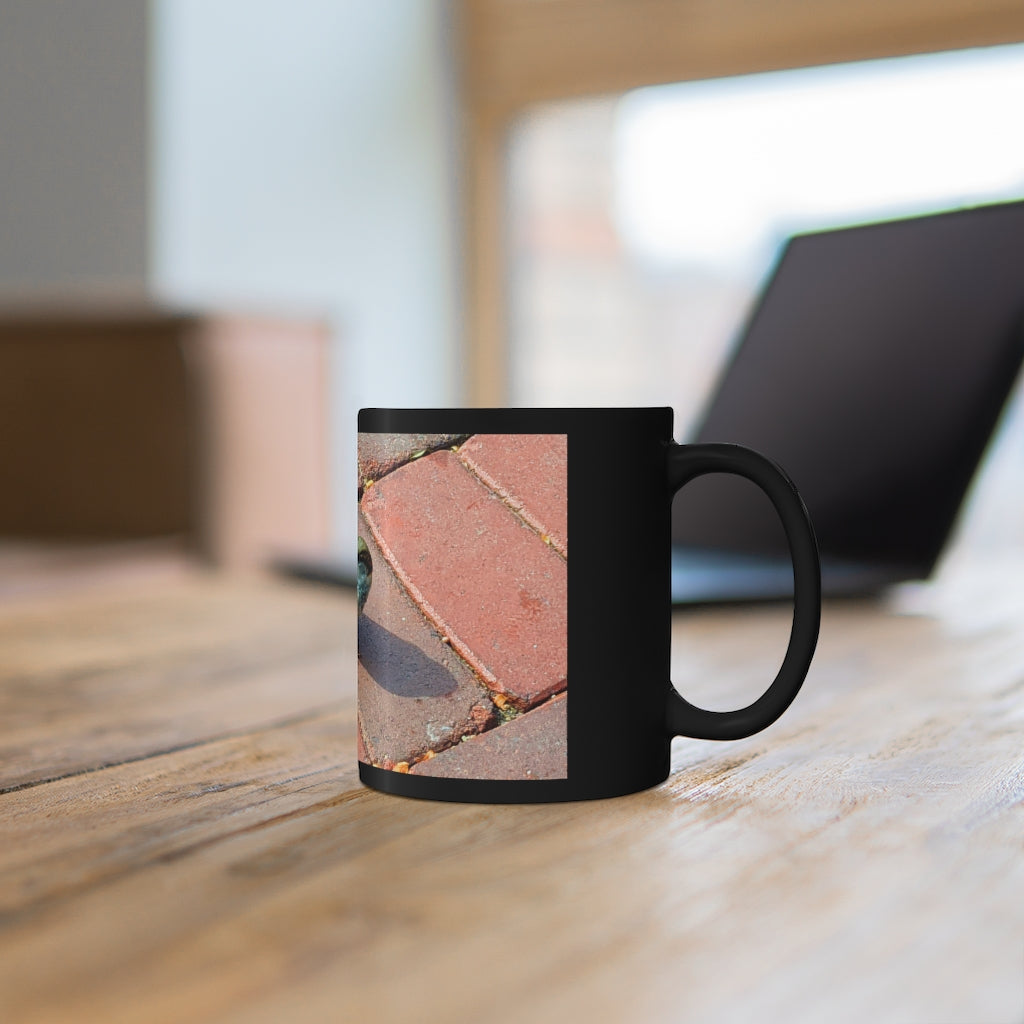 A sleek 11oz black ceramic mug with a C-handle, perfect for coffee, tea, or hot chocolate, showcasing customizable design options.