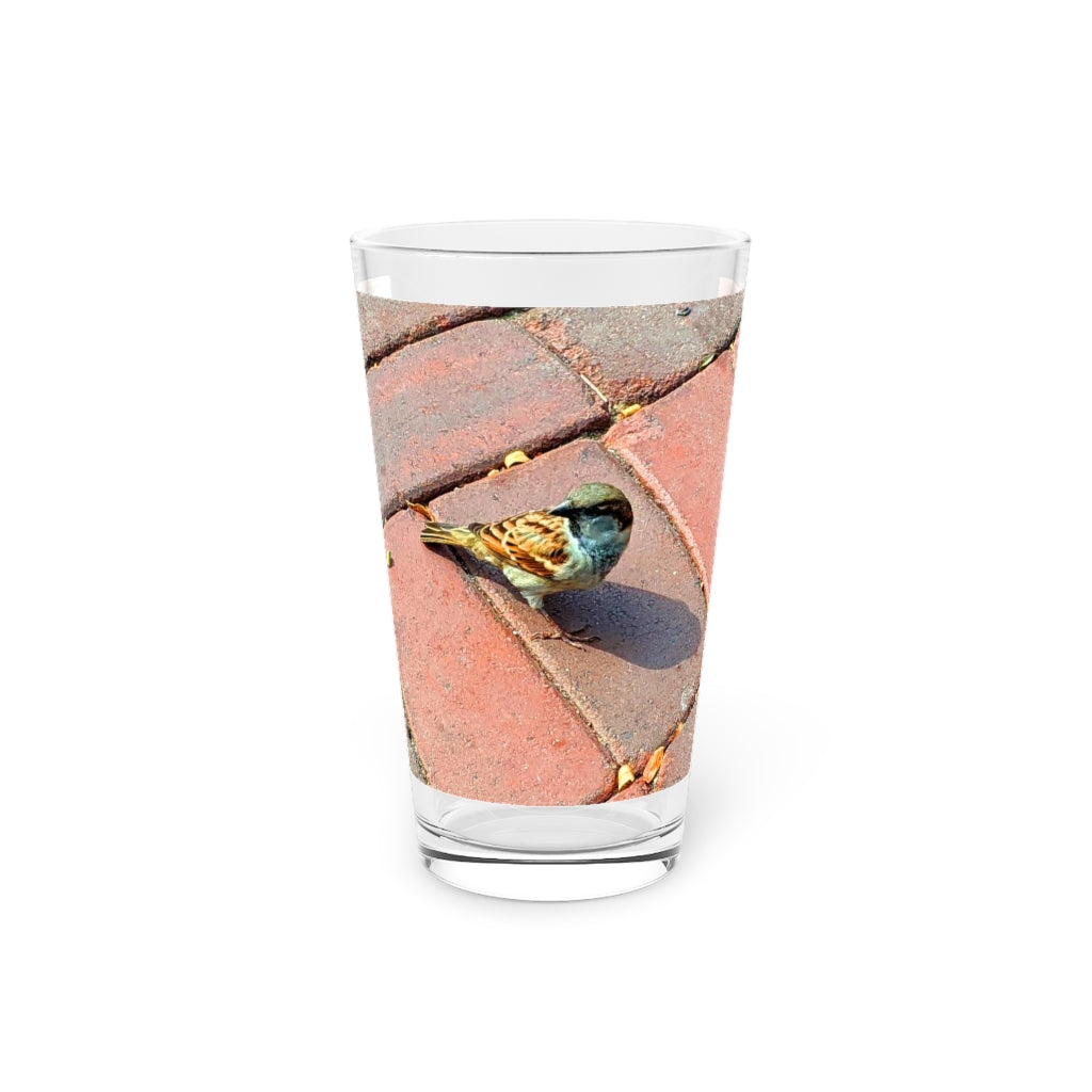 A clear 16oz Bird Pint Glass showcasing a custom printed design, perfect for beverages.