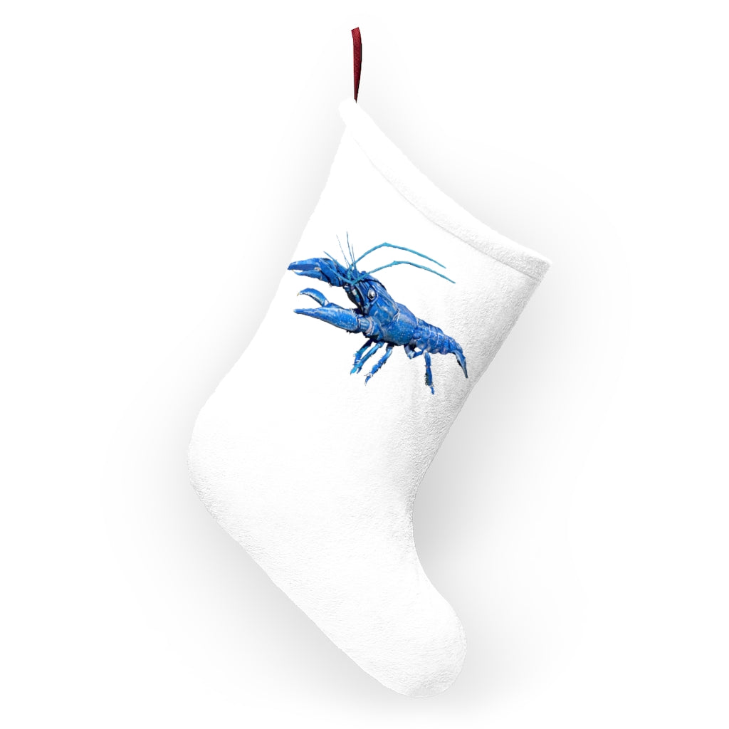 A cozy blue crawfish Christmas stocking hanging by a fireplace, featuring a soft fleece texture and a twill ribbon loop.