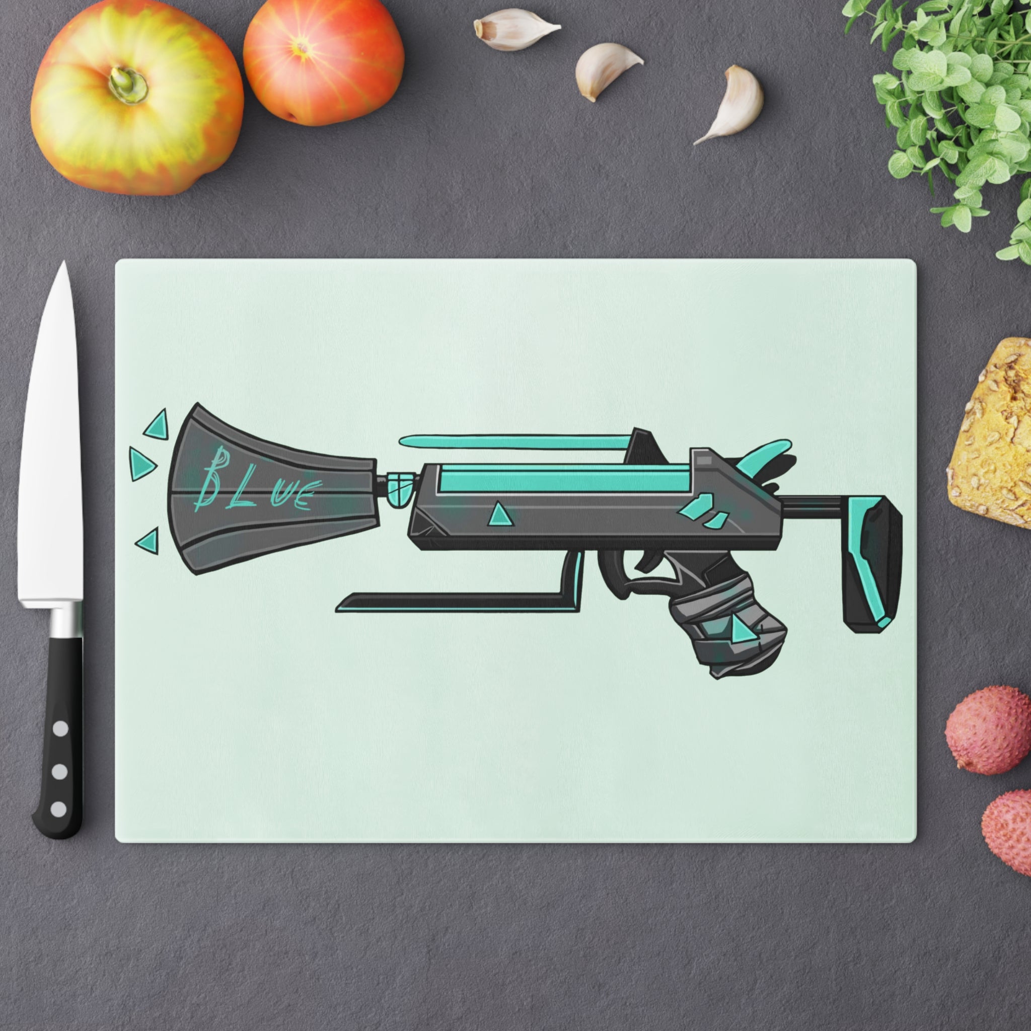 Blue Gun Cutting Board made of tempered glass with rubber dots for stability, showcasing a unique design.