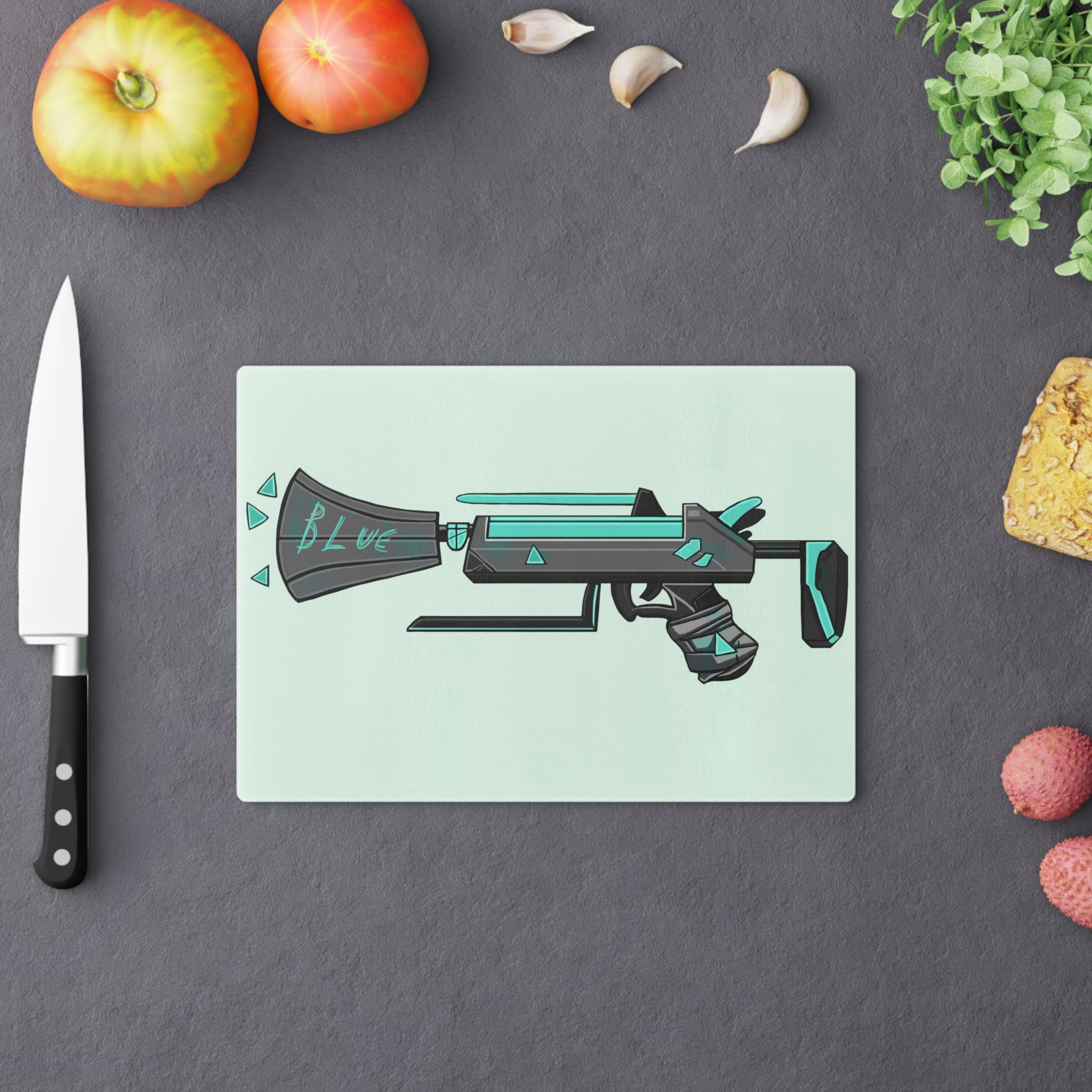 Blue Gun Cutting Board made of tempered glass with rubber dots for stability, showcasing a unique design.